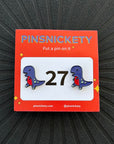 pinsnickety t-rex horse show number pins with their product packaging car on a black background
