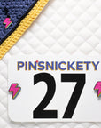 pinsnickety lighting bolt charm on a bonnet and horse show number pins on a saddle pad