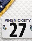 pinsnickety flying unicorn charm on a bonnet and horse show number pins on a saddle pad