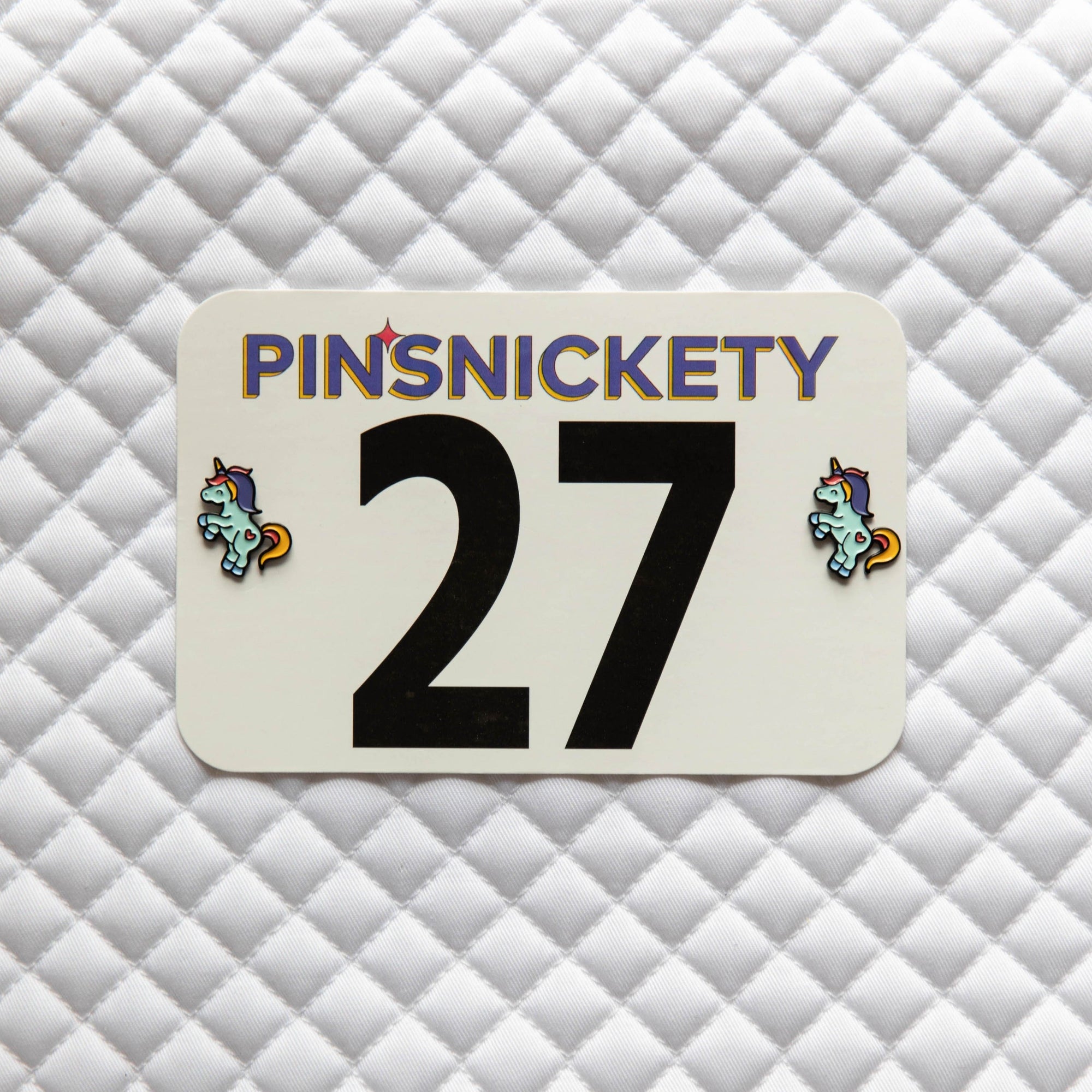 Pinsnickety Flying Unicorn horse show number pins on a saddle pad